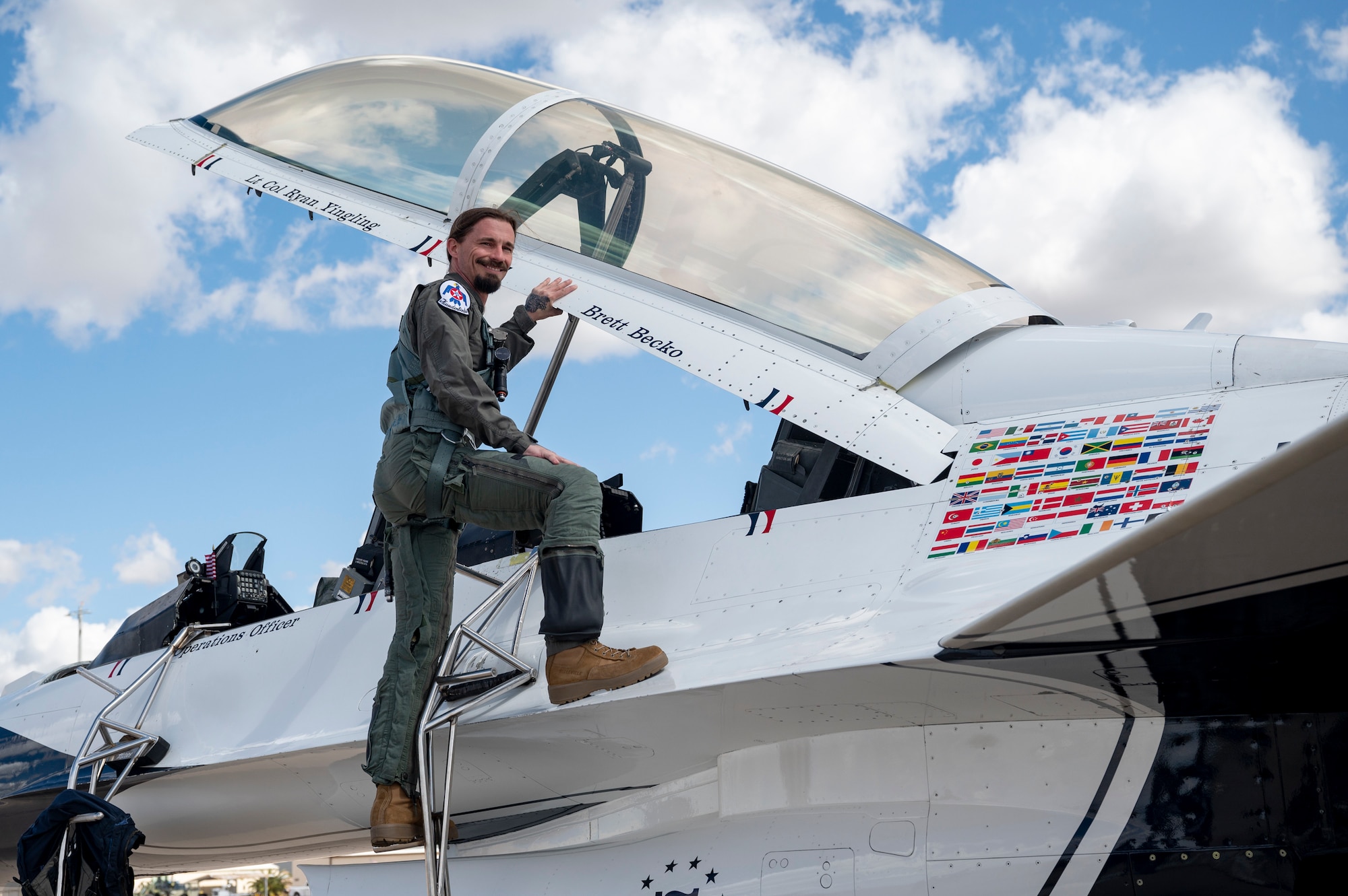 Photo of a man smiling as he boards a fighter jet.