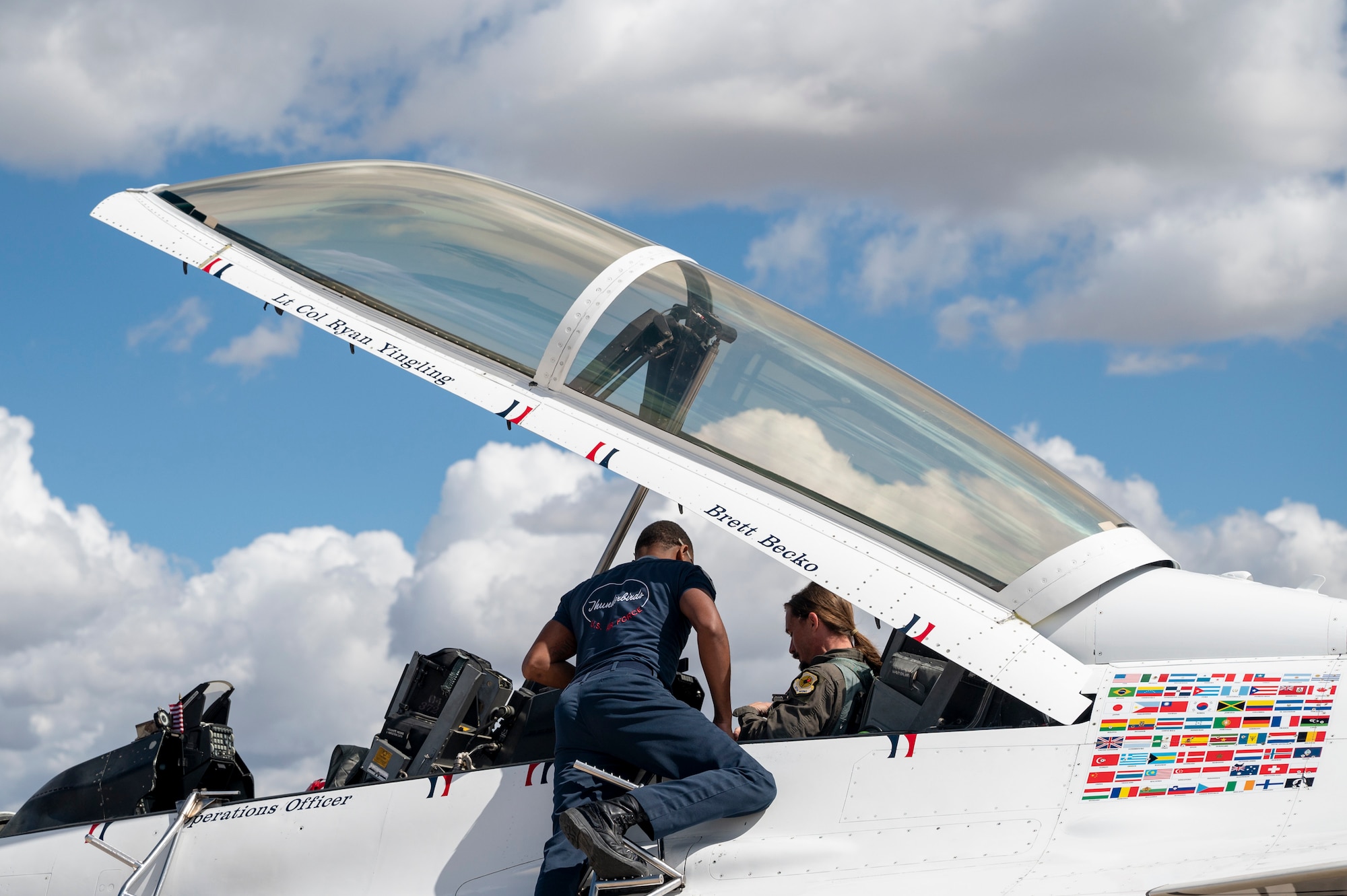 Photo of a man getting seated in an aircraft with the help of another man.