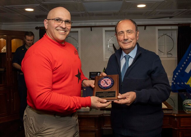 (March 23, 2023)  Rear Adm. Dennis Velez, commander, Carrier Strike Group (CSG) 10, George H.W Bush CSG, presents a plaque to President of Sicilian Region Renato Schifani aboard the Nimitz-class aircraft carrier USS George H.W. Bush (CVN 77), March 23, 2023. The George H.W. Bush Carrier Strike Group is on a scheduled deployment in the U.S. Naval Forces Europe area of operations, employed by U.S. Sixth Fleet to defend U.S., allied and partner interests.