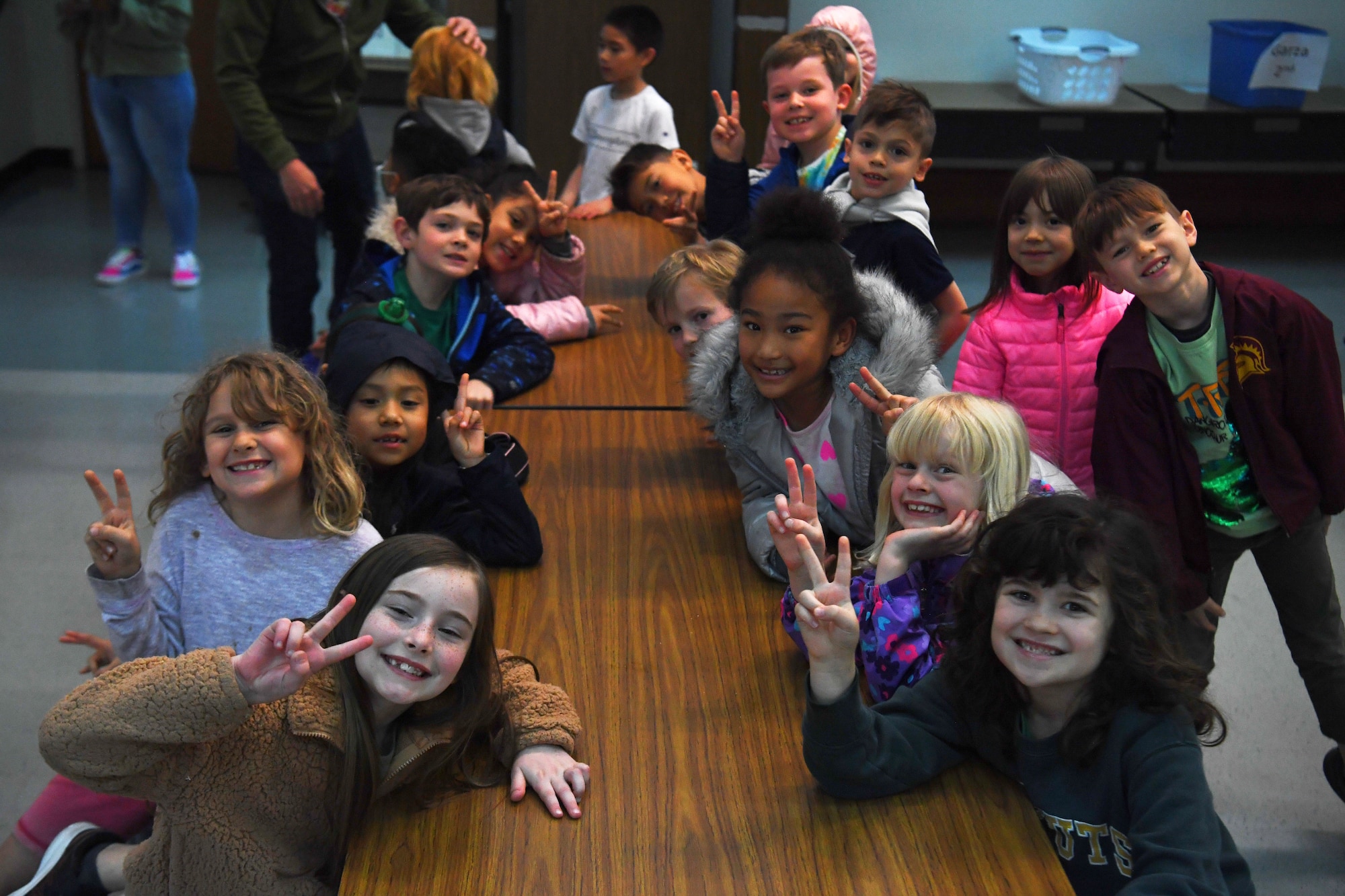 Students from Yokota West Elementary School pose for a photo before traveling to the Yokota Passenger Terminal at Yokota Air Base, Japan, March 17, 2023. The kindergarten and first-grade classes traveled to the terminal with their teachers and parent chaperones to learn about the mission of the 730th Air Mobility Squadron and get an inside-look at a visiting C-5M Super Galaxy. (U.S. Air Force photo by Tech. Sgt. Taylor A. Workman)