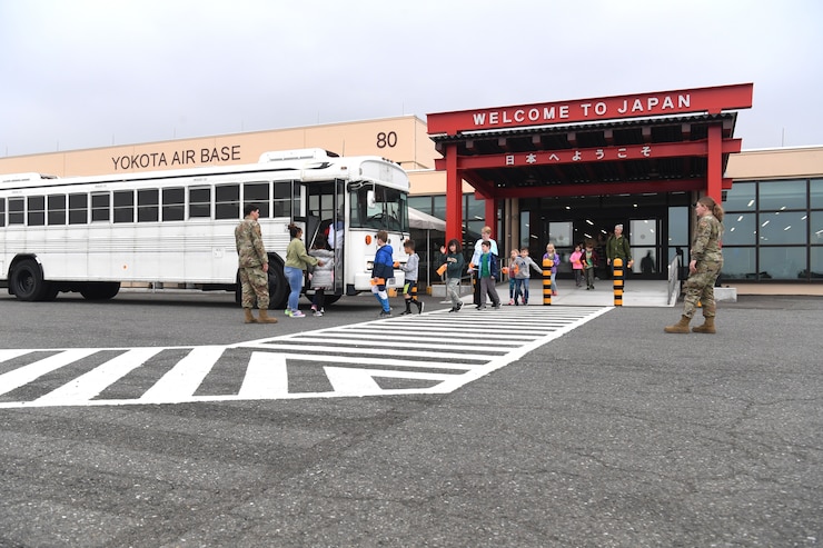 Passenger service agents with the 730th Air Mobility Squadron usher children from Yokota West Elementary School onto buses during a field trip of the Yokota Passenger Terminal at Yokota Air Base, Japan, March 17, 2023. Airmen from the 374th Logistics Readiness Squadron drove the buses and escorted field trip attendees to the visiting Air Mobility Command C-5M Super Galaxy, which has been a feature on the Yokota flightline for a two-week ground trainer exercise hosted by the 730th AMS. (U.S. Air Force photo by Tech. Sgt. Taylor A. Workman)