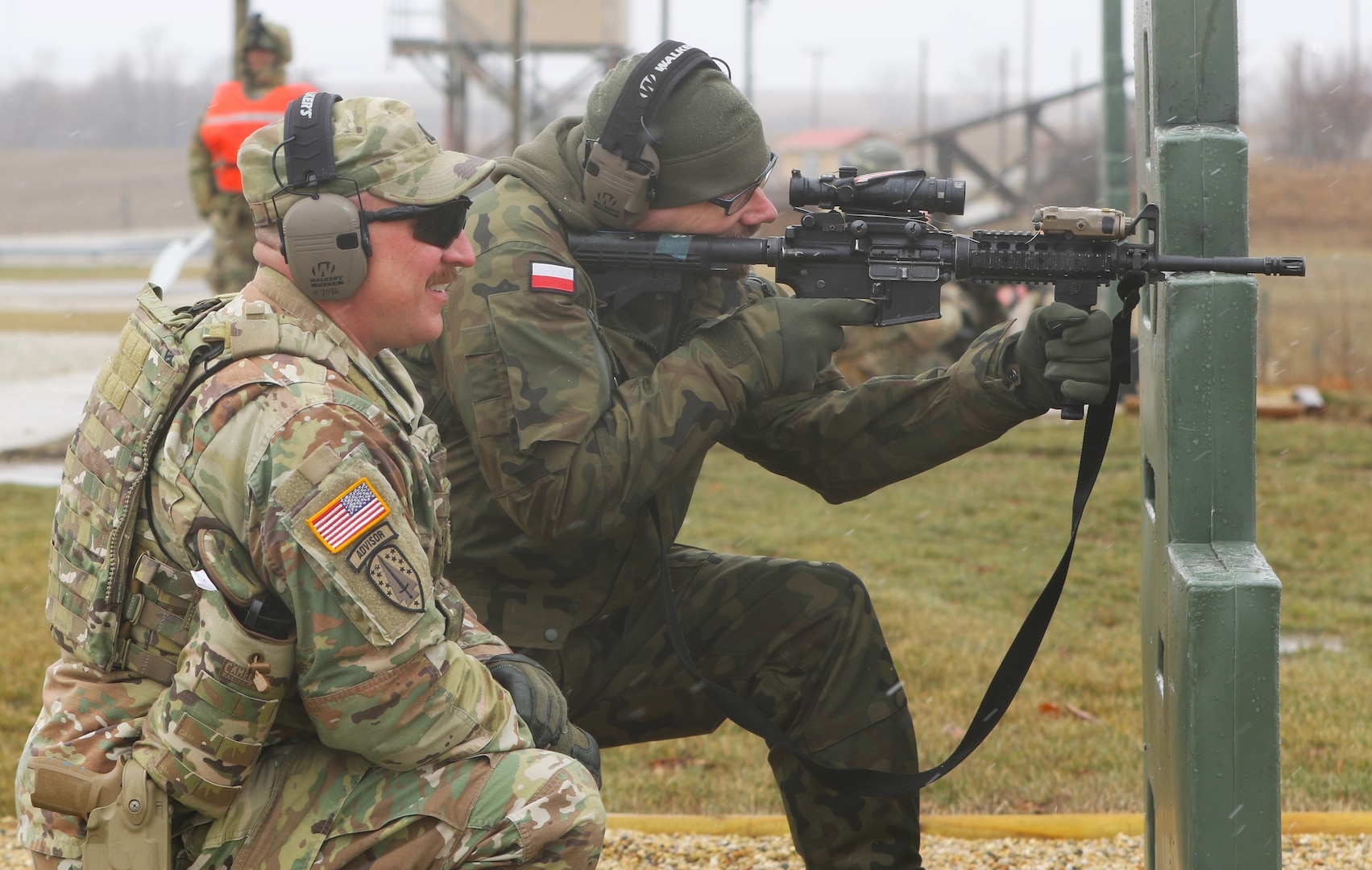 Illinois Army National Guard Capt. Drew Weaver discusses the firing of the M-4 with Maj. Andrew Majcherek of the Polish Territorial Defense Force on the range at the Illinois Army National Guard's Marseilles Training Area. Weaver was one of four Illinois National Guard Soldiers awarded the bronze Polish Armed Forces Medal on March 25, 2023, for their work training Polish Territorial Defense Force Soldiers in Poland in May and June 2022.
