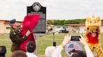 male servicemember uncovering historical marker