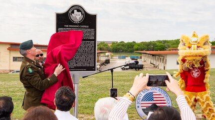 male servicemember uncovering historical marker