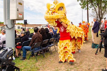 two dragons walking behind group of people seated