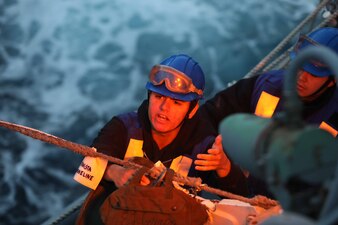 BM3 George Kingston hooks up lines aboard USS Thomas Hudner (DDG 116) during a replenishment-at-sea in the Atlantic Ocean.