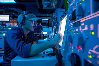 OS2 Anthony Pizano establishes communications with a helicopter during flight quarters aboard USS Decatur (DDG 73).