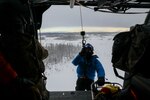 Alaska Air National Guard Staff Sgt. Kaden Wernofski, a 210th Rescue Squadron special missions aviator, operates the hoist to lift a 212th RQS pararescueman into an HH-60G Pave Hawk helicopter during a training mission over the Lower Susitna Valley near Anchorage, Alaska, Feb. 7, 2023. The HH-60G and rescue personnel along with a 211th RQS HC-130J Combat King II aircraft sit alert for the federal search and rescue mission across Alaska’s vast Arctic region.