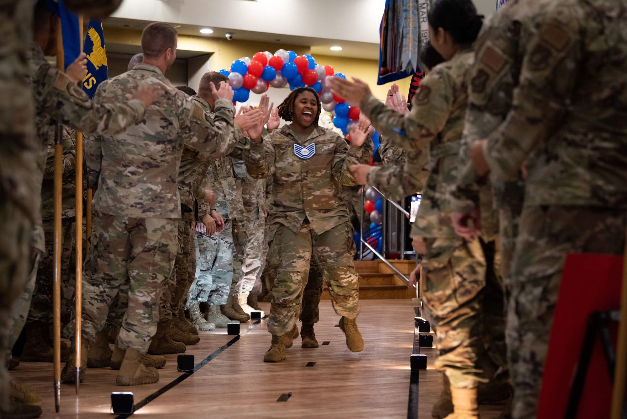 A technical sergeant select high fives her peers during a promotion release ceremony at Osan Air Base, South Korea, July 21, 2022. Technical sergeants are experts in their career field, providing supervision to their subordinates and assisting their team with attention to detail, positive work climates and clear communication. (U.S. Air Force photo by Senior Airman Megan Estrada)