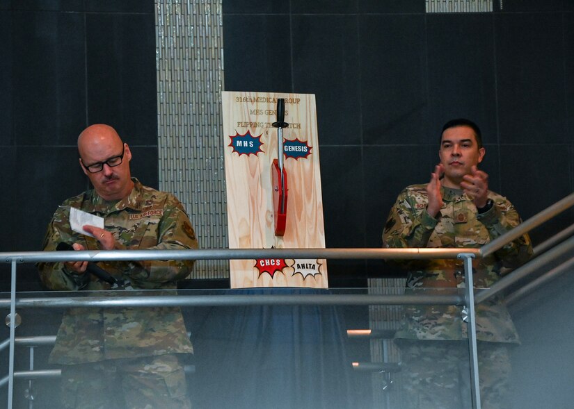 Col. Robert A. Corby, 316th Medical Group commander, and CMSgt. William Schumacher, 316th MDG Command Chief, applaud the welcoming of MHS Genesis