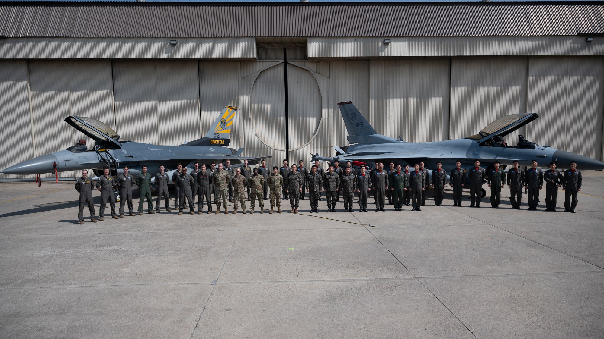 U.S. Air Force Airmen from the 8th Fighter Wing and Republic of Korea Air Force Airmen from the 38th Fighter Group, stand with ROK Chairman of the Joint Chiefs of Staff Gen. Seung-Kyum Kim, near an airframe from each of the respective units at Kunsan Air Base, ROK, March 20, 2023. Kim is the ROKs highest ranking military officer and leads the JCS, which has operational control over all ROK military personnel. (U.S. Air Force photo by Staff Sgt. Isaiah J. Soliz)