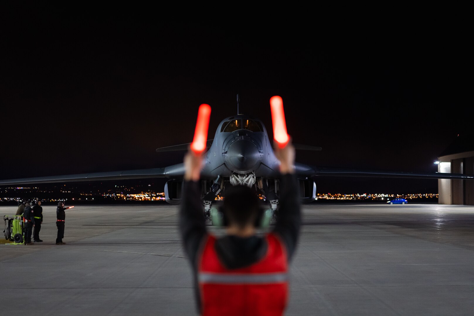 Maintainers from the 28th Aircraft Maintenance Squadron marshall a B-1B Lancer into position  after it returns from Nellis Air Force Base, Nevada, at Ellsworth AFB, South Dakota, March 24, 2023.