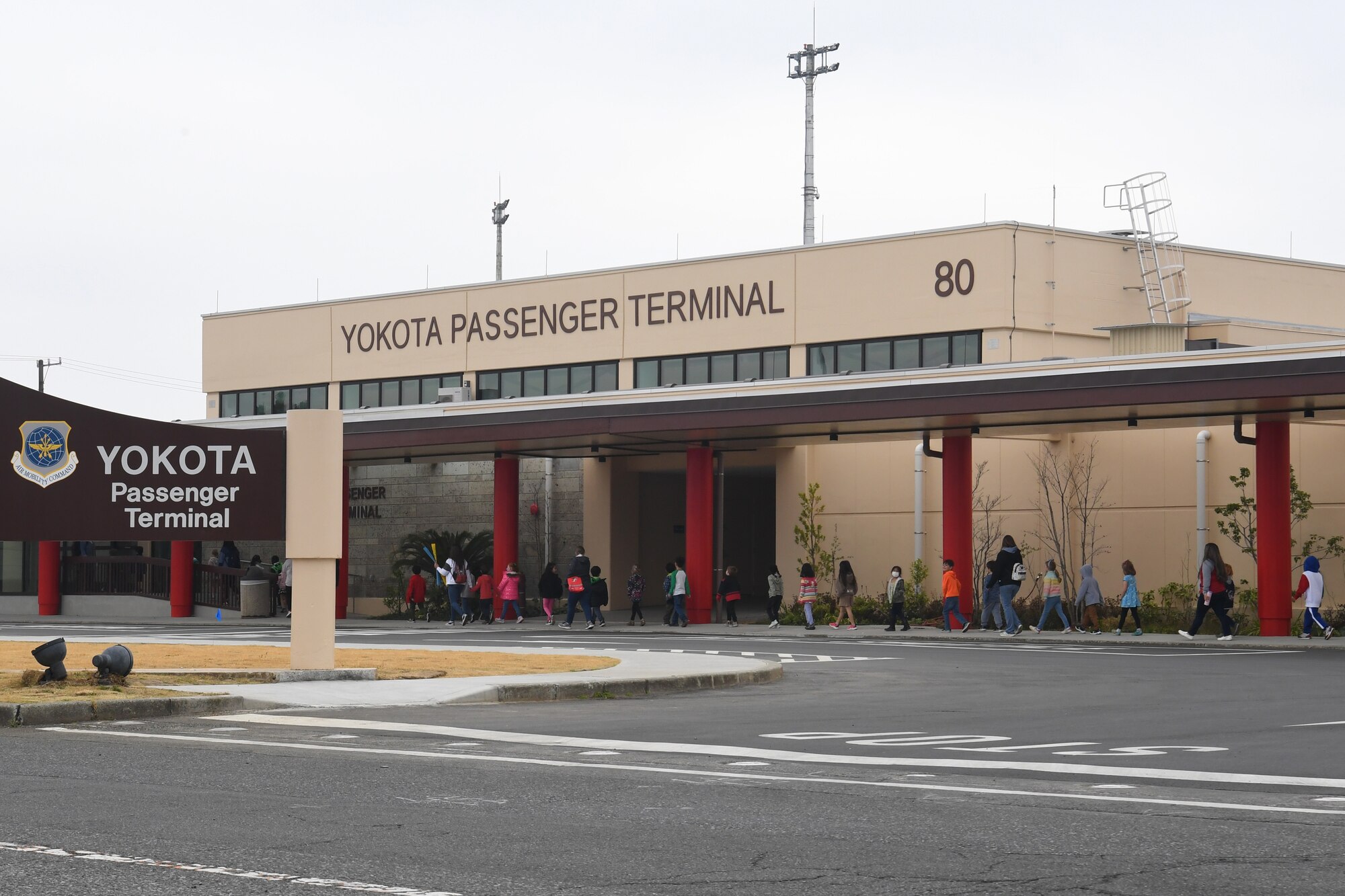 Students from Yokota West Elementary School walk into the Yokota Passenger Terminal at Yokota Air Base, Japan, March 17, 2023. The kindergarten and first-grade classes toured the terminal with their teachers and parent chaperones to learn about the mission of the 730th Air Mobility Squadron and get an inside-look at a visiting Air Mobility Command C-5M Super Galaxy. (U.S. Air Force photo by Tech. Sgt. Taylor A. Workman)