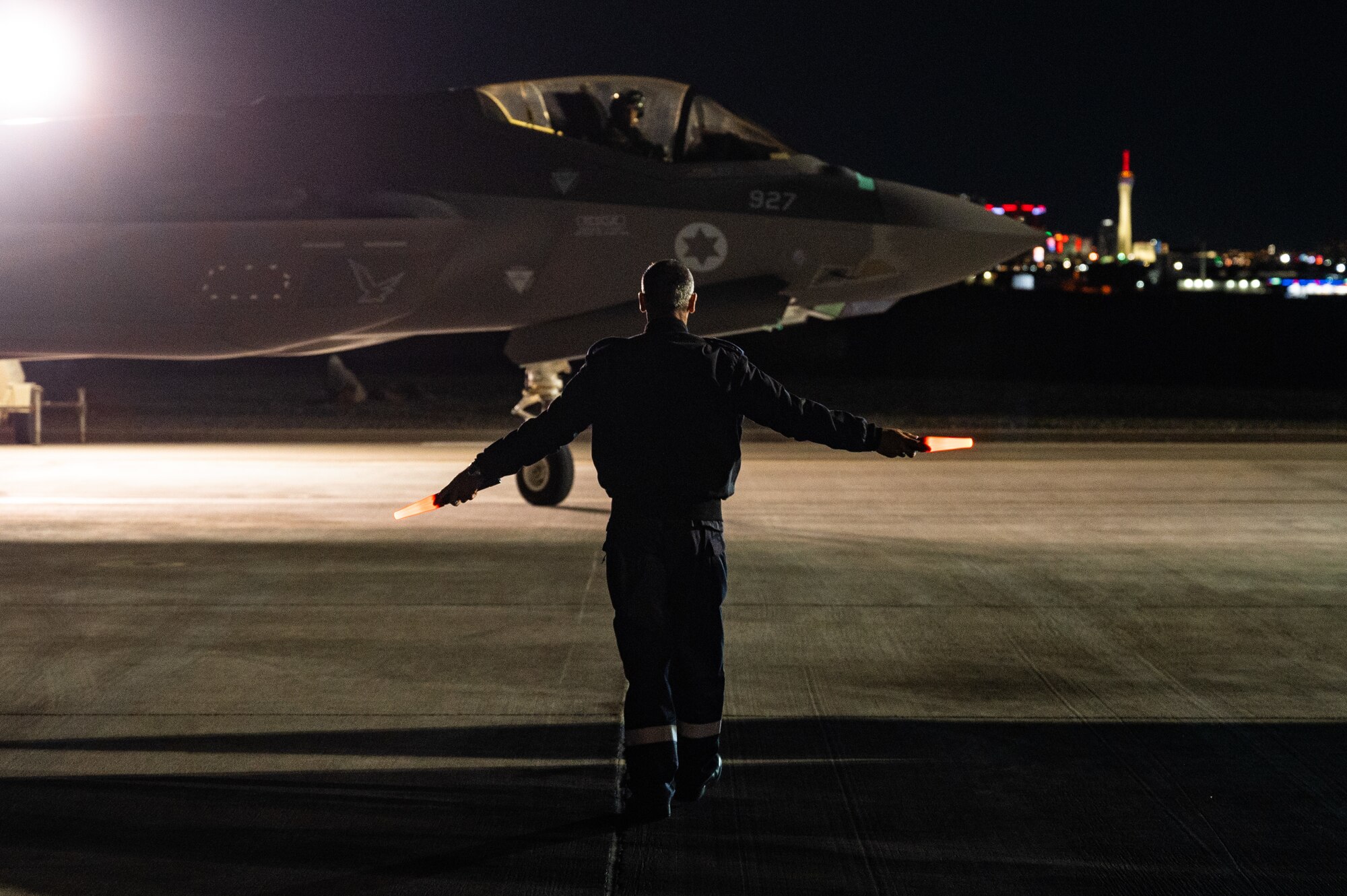 An Israeli Air Force member marshals an F-35I Adir to its spot after a Red Flag-Nellis 23-2 mission at Nellis Air Force Base, Nevada, March 16, 2023.