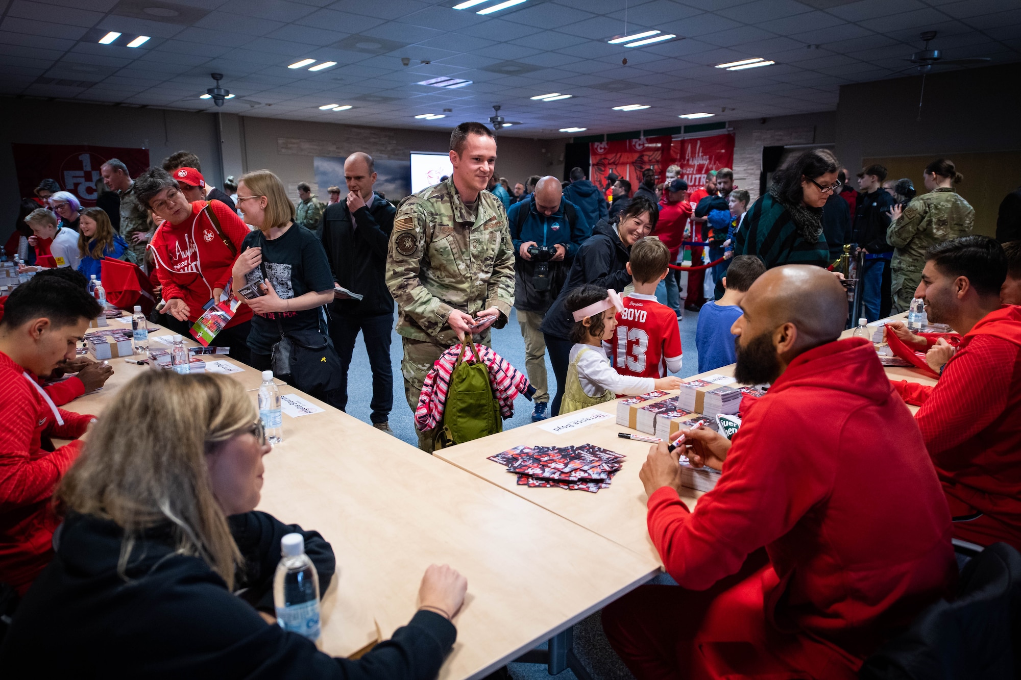 Department of Defense personnel meet players and coaches from the Football Club Kaiserslautern (1. FCK) team at Ramstein Air Base, Germany, March 23, 2023. While visiting RAB, members of 1.FCK met with fans and participated in a meet-and-greet where they were asked questions and signed memorabilia. (U.S. Air Force photo by Airman 1st Class Jared Lovett)