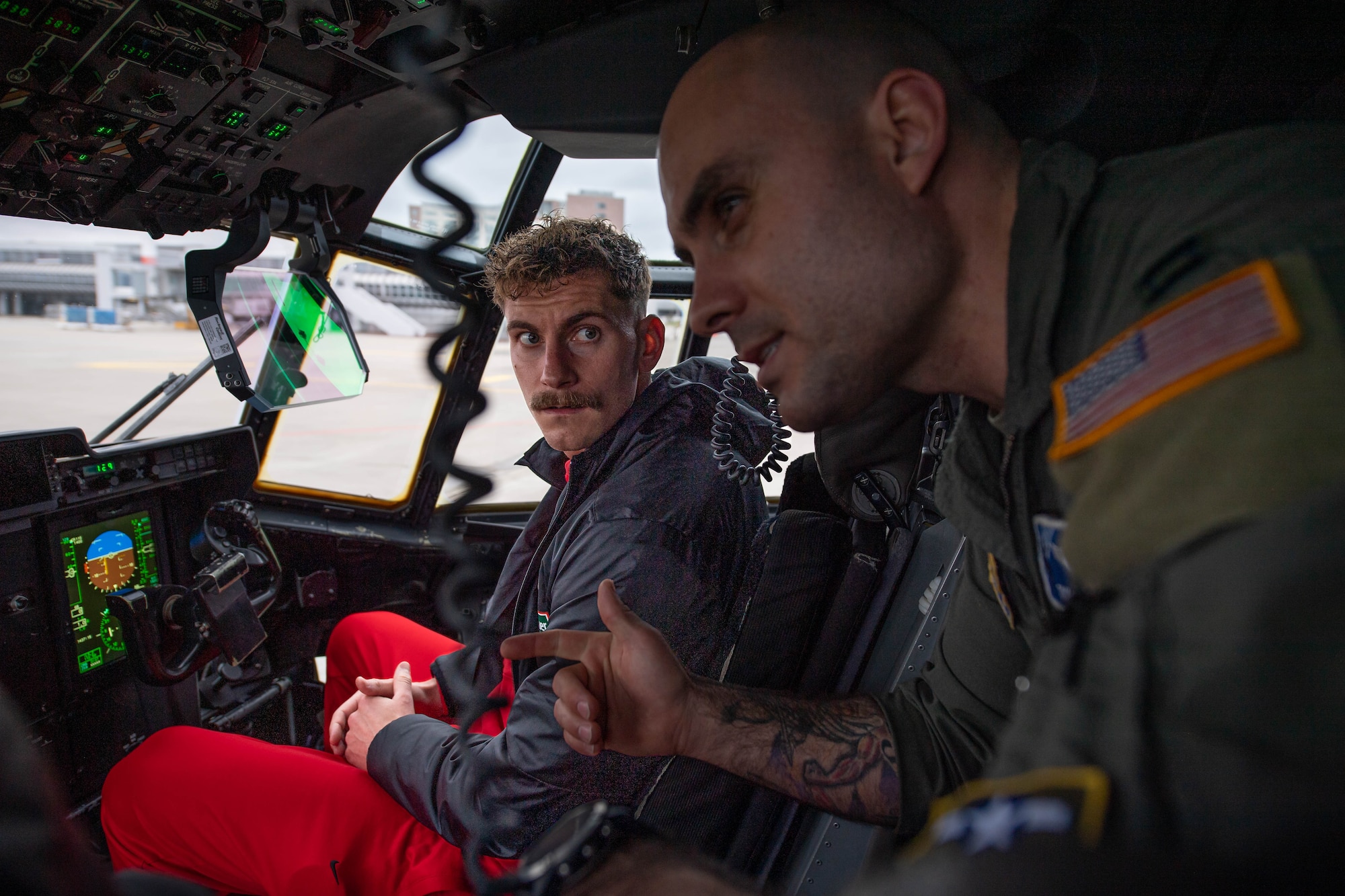 U.S. Air Force Capt. Taylor Escobar, right, 37th Airlift Squadron C-130J Super Hercules pilot, explains the capabilities of the aircraft, to Kevin Cross, left, Football Club Kaiserslautern (1. FCK) player, at Ramstein Air Base, Germany, March 23, 2023. With 1.FCK being the largest sports team in the region, meeting with leadership and fans from RAB opens the door to future partnerships and opportunities between the team and on-base organizations. (U.S. Air Force photo by Airman 1st Class Jared Lovett)