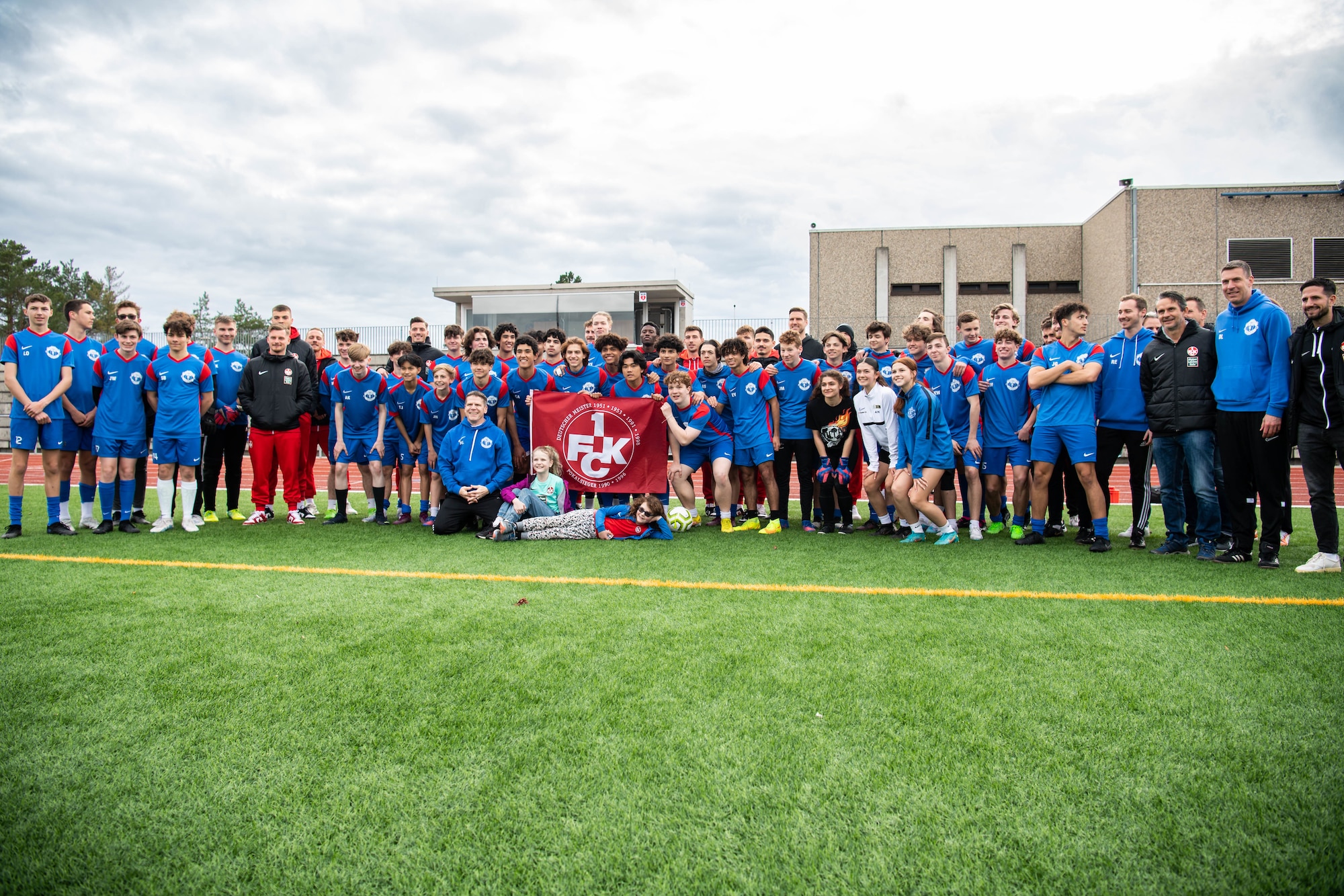 Football Club Kaiserslautern (1. FCK) players and coaches pose for a photo with students and staff from Ramstein High School at Ramstein Air Base, Germany, March 23, 2023. The 1.FCK visit was the first time since the 1970’s that the team has visited the base and provided the players the opportunity to spend time with American fans stationed here. (U.S. Air Force photo by Airman 1st Class Jared Lovett)