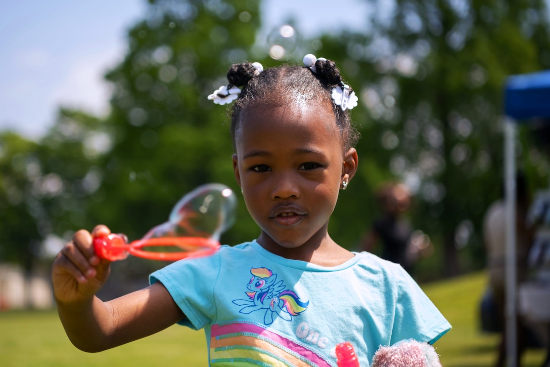 A military child plays with bubbles.
