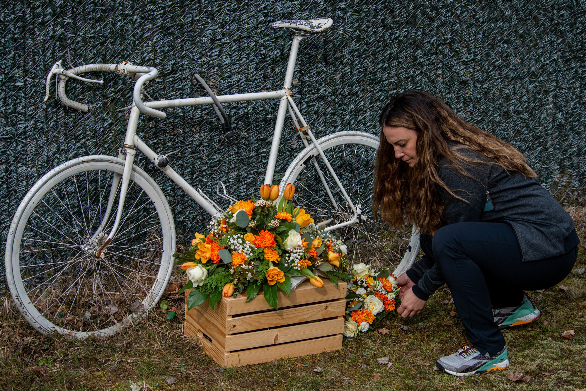 Airmen leaves flowers at roadside memorial