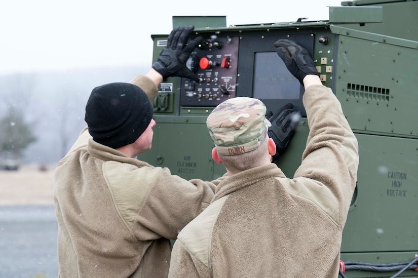 Airman 1st Class Nathan Fulghum, left, and Senior Airman Larry Dunn, right, from 316th Civil Engineer Squadron set up a generator for the Expeditionary Airfield Lighting System during a training event, March 14, 2023, Fort Indiantown Gap, Annville, Pa. Civil engineers from the 11th and 316th Civil Engineer Squadrons came together to form a team that will represent Air Force District of Washington at Readiness Challenge IX, a competition aimed to test Air Force Civil Engineers’ contingency capabilities. The EALS is a rapidly installed runway lighting system that supports flying operations during periods of reduced visibility on contingency airfields, and installing the system is one of the many potential competition events at the Readiness Challenge. (U.S. Air Force photo by Kristen Wong)