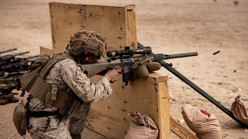 A Marine fires a weapon while kneeling.