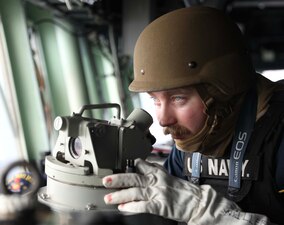Ensign Derek Miller stands watch aboard USS Milius (DDG 69) during a general quarters drill in the South China Sea.