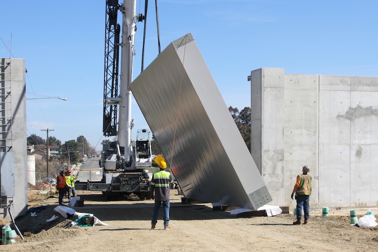 Contractors install a 19-ton floodgate March 10 on the Alcoa Dike alongside the Temescal Wash in Corona, California.