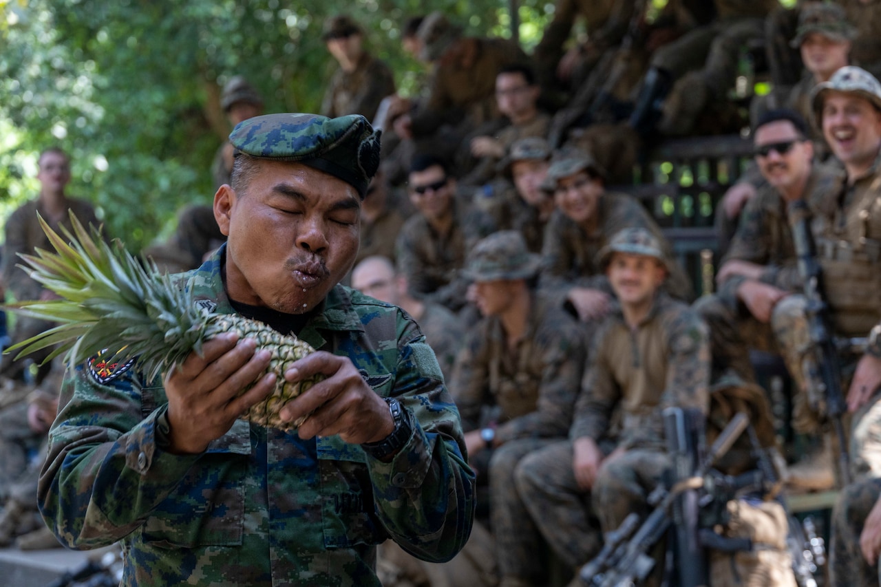 A Marine eats a pineapple.