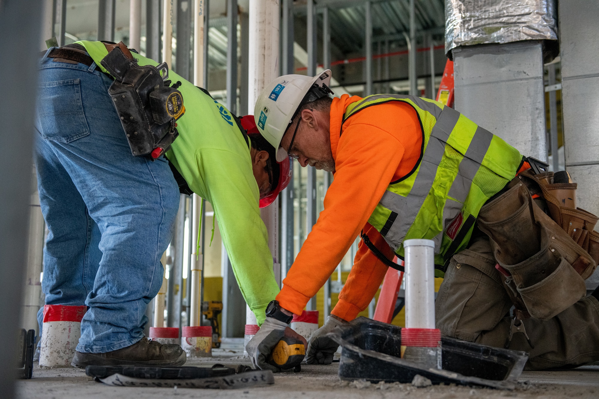 Two construction workers take measurements