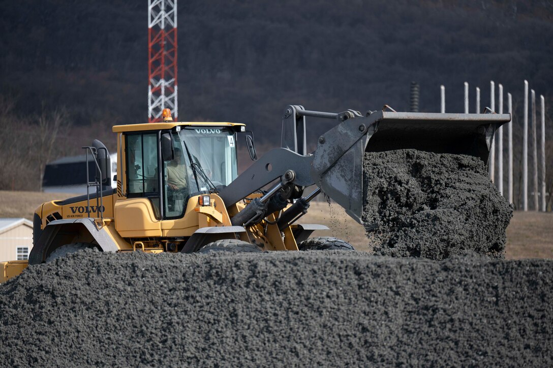 A loader builds a berm during a training event, March 14, 2023, Fort Indiantown Gap, Annville, Pa. Civil engineers from the 11th and 316th Civil Engineer Squadrons came together to form a team that will represent Air Force District of Washington at Readiness Challenge IX, a competition aimed to test Air Force Civil Engineers’ contingency capabilities. Berms are created to mitigate or divert runoff and their construction is one of the many potential competition events at the Readiness Challenge. (U.S. Air Force photo by Kristen Wong)
