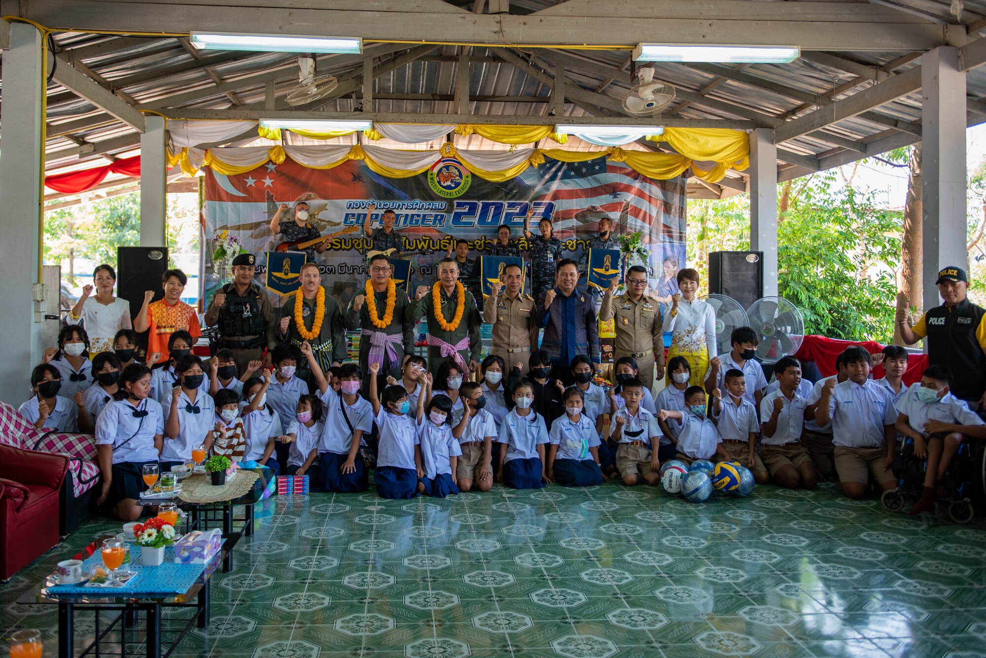 Photo of members from the U.S. Air Foce, Royal Singapore Air Force, and Royal Thailand Air Force with community leaders and students during civic action engagement