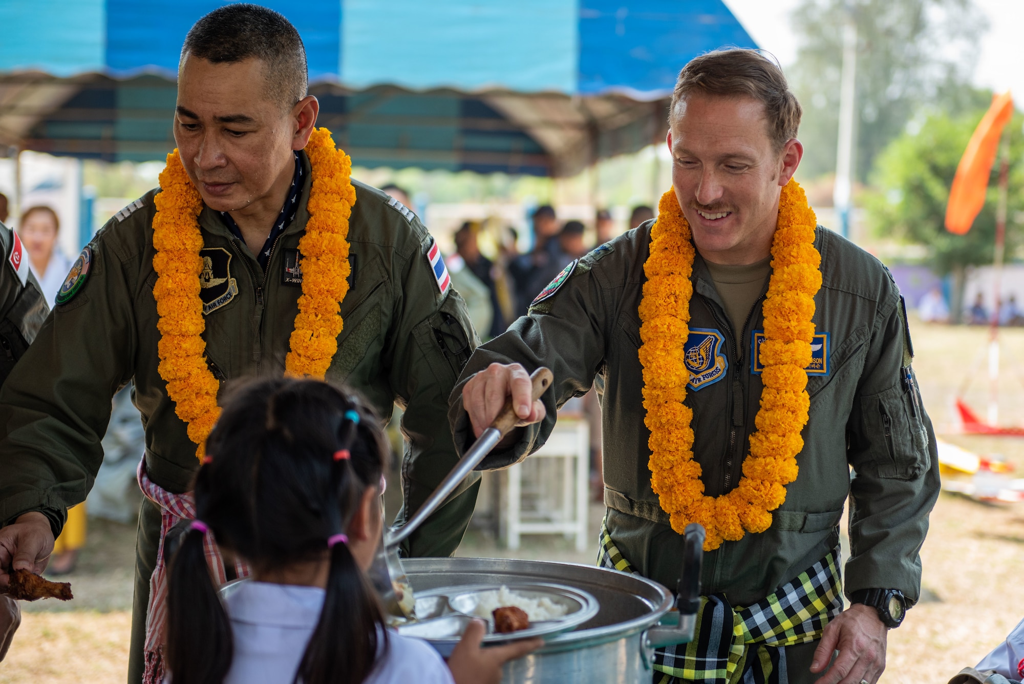 Photo of Royal Thailand air force and US Air Force Cope Tiger exercise directors serving food together.