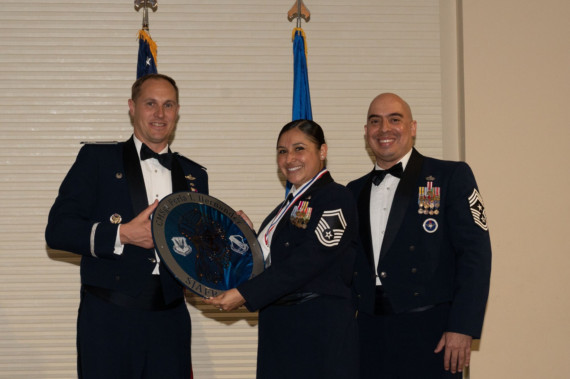 Col. Lucas Teel, 4th Fighter Wing commander, and Chief Master Sgt. Peter Martinez, 4th FW command chief, present a plaque to Senior Master Sgt. Perla Hernandez, 4th Force Support Squadron sustainment services flight chief, during a Chief Master Sergeant Recognition Ceremony at Seymour Johnson Air Force Base, North Carolina, March 24, 2023. No more than 1.25% of the Air Force enlisted force may hold the rank of chief master sergeant by federal law. (U.S. Air Force photo by Airman 1st Class Rebecca Sirimarco-Lang)