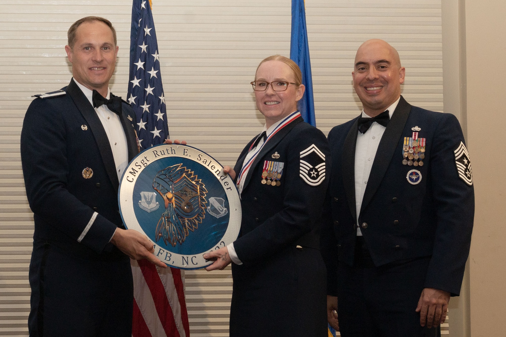 Col. Lucas Teel, 4th Fighter Wing commander, and Chief Master Sgt. Peter Martinez, 4th FW command chief, present a plaque to Senior Master Sgt. Ruth Salender, 4th Comptroller Squadron senior enlisted leader, during a Chief Master Sergeant Recognition Ceremony at Seymour Johnson Air Force Base, North Carolina, March 24, 2023. At the rank of chief master sergeant, Airmen assume the responsibility of developing purposeful strategies to lead Airmen with character and mission focus. (U.S. Air Force photo by Airman 1st Class Rebecca Sirimarco-Lang)