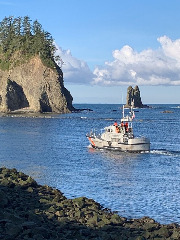 Photo of a US Coast Guard vessel in the water approaching a sea dike.