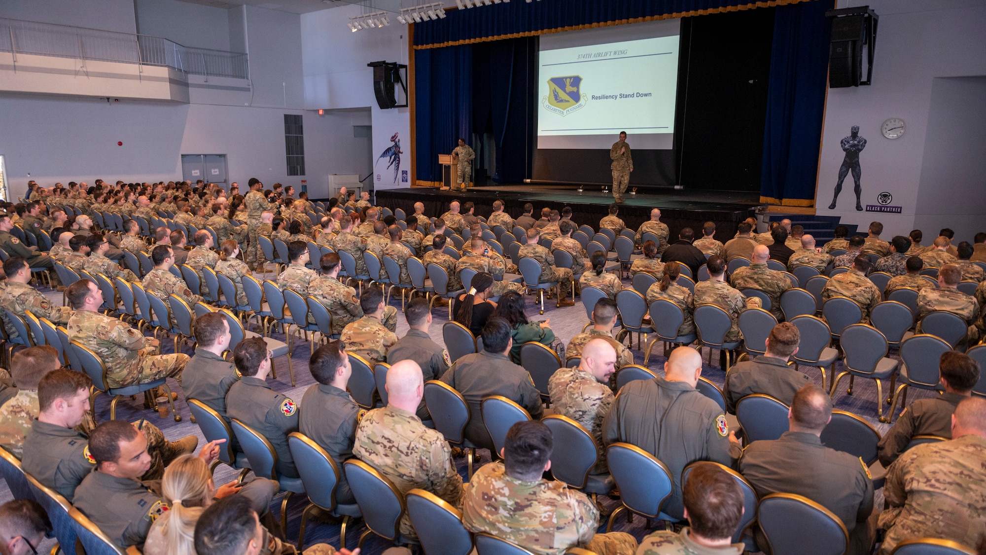 Hundreds of airmen watch presenters on a stage