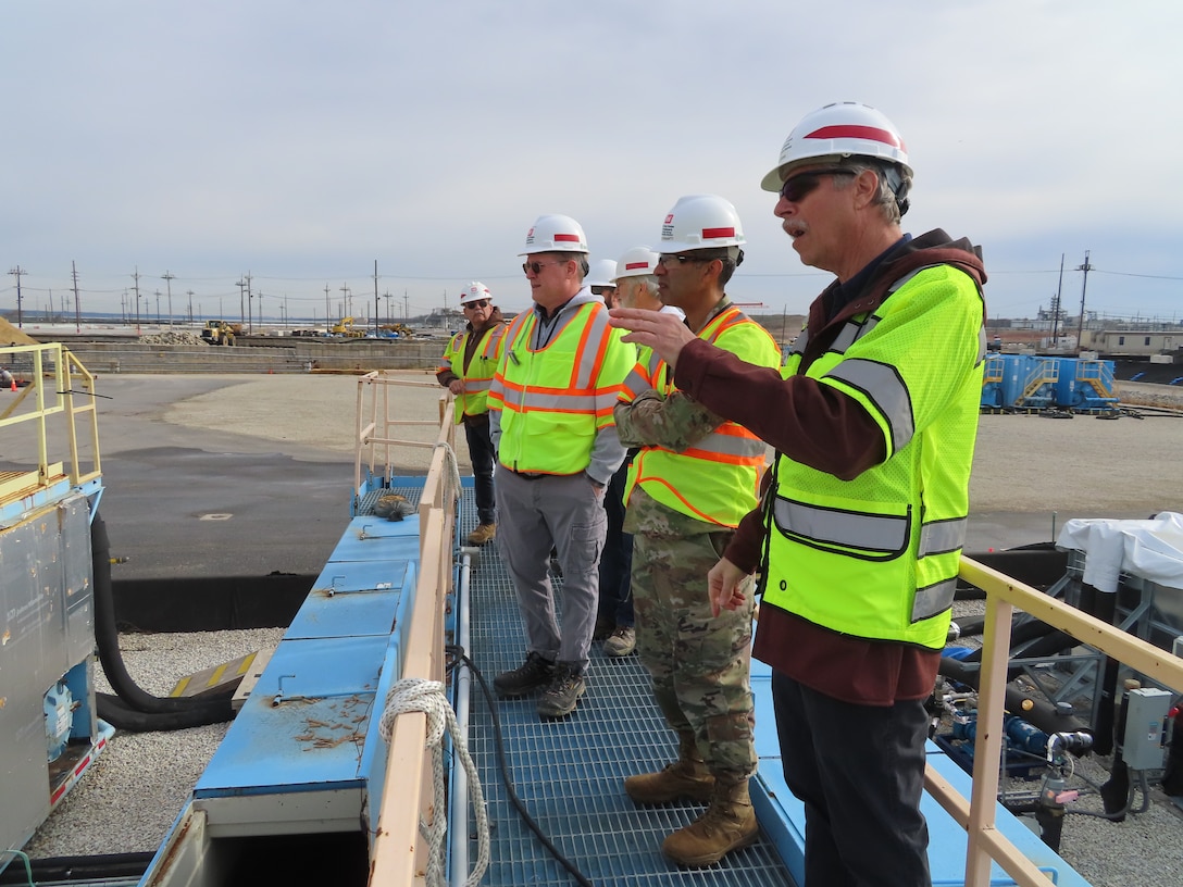 Team members discuss environmental remediation efforts while looking out over the site