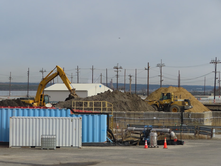 An excavator removes contaminated soil from a site