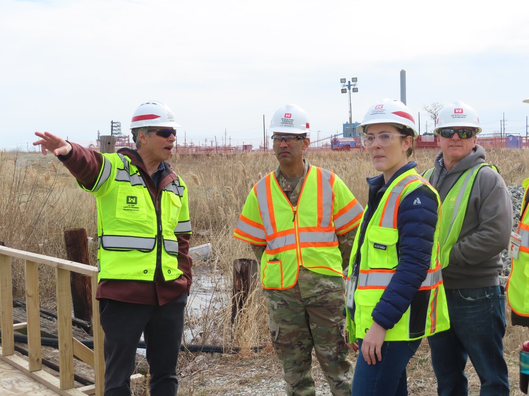 Team members stand and discuss issues at an environmental remediation site