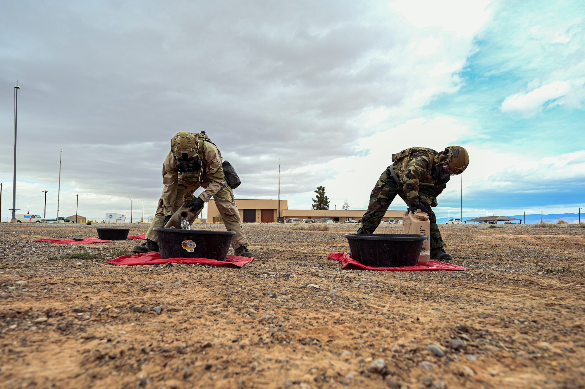 U.S. Air Force Airman 1st Class Spencer Pettingill, left, and U.S. Air Force Senior Airman Danielle Alpi, 49th Civil Engineer Squadron explosive ordnance disposal apprentices, prepare for a chemical munition decontamination exercise at Holloman Air Force Base, New Mexico, March 23, 2023. The 49th CES EOD flight works meticulously to provide maximum safety when it comes to dealing with chemical contaminations, ensuring that any volatile materials are properly contained. (U.S Air Force photo by Airman 1st Class Isaiah Pedrazzini)