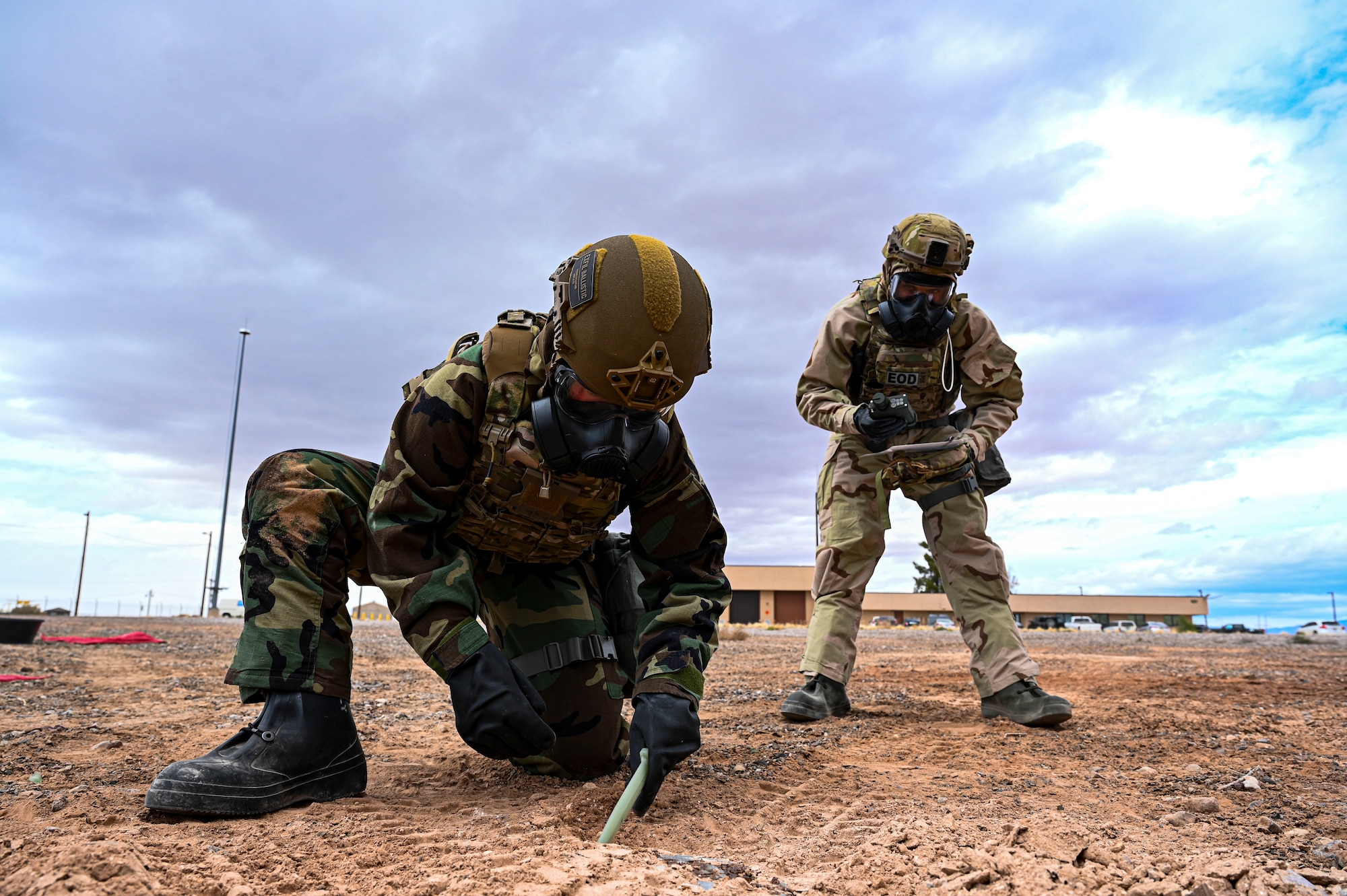 U.S. Air Force Senior Airman Danielle Alpi, left, and U.S. Air Force Airman 1st Class Spencer Pettingill, 49th Civil Engineer Squadron explosive ordnance disposal apprentices, dig up a mock M23 chemical landmine during a chemical munition decontamination exercise at Holloman Air Force Base, New Mexico, March 23, 2023. The 49th CES EOD flight constantly trains for different scenarios to better prepare for any extreme situations that they may encounter. (U.S Air Force photo by Airman 1st Class Isaiah Pedrazzini)
