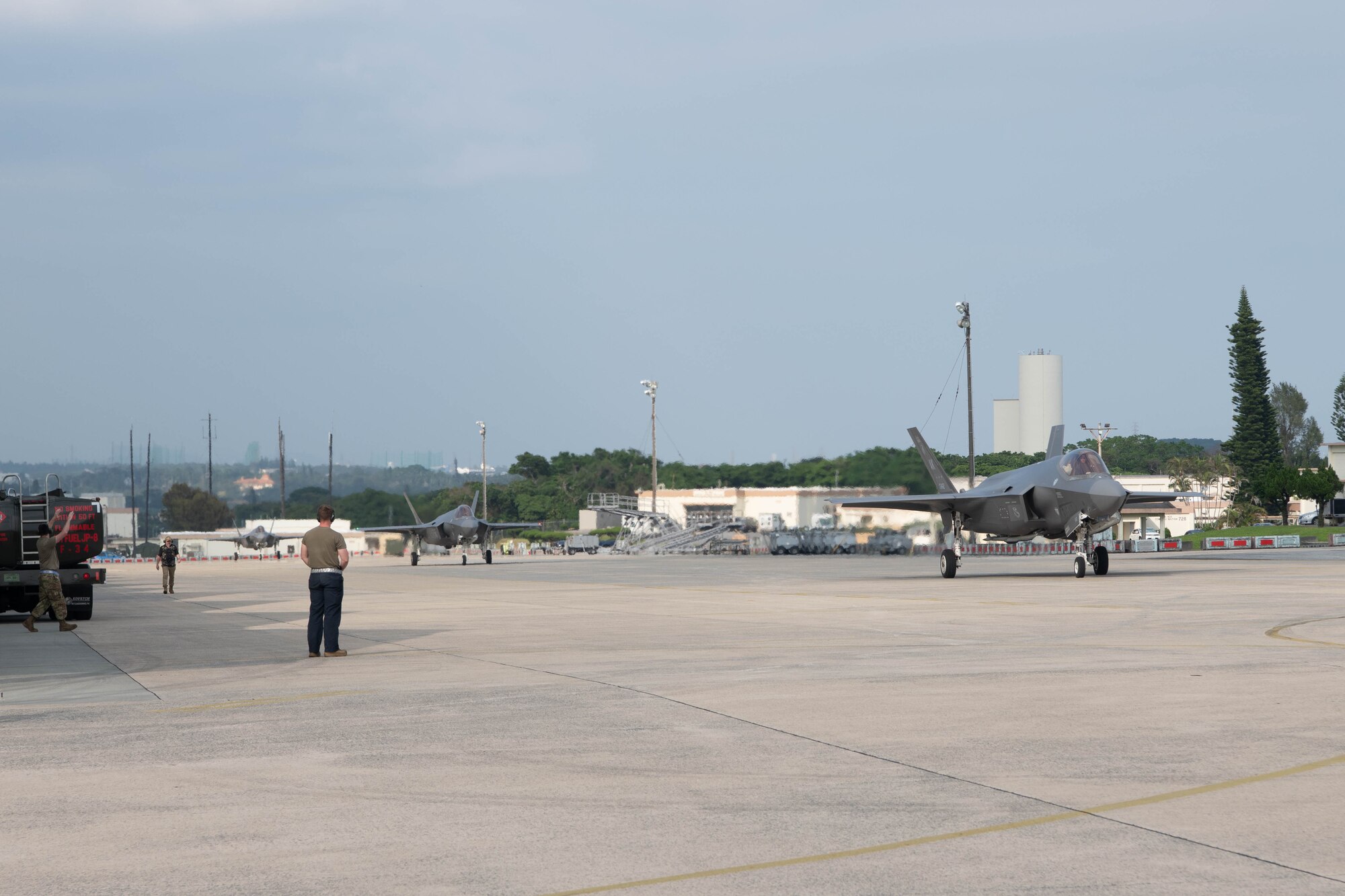 Aircraft taxi down a flightline.