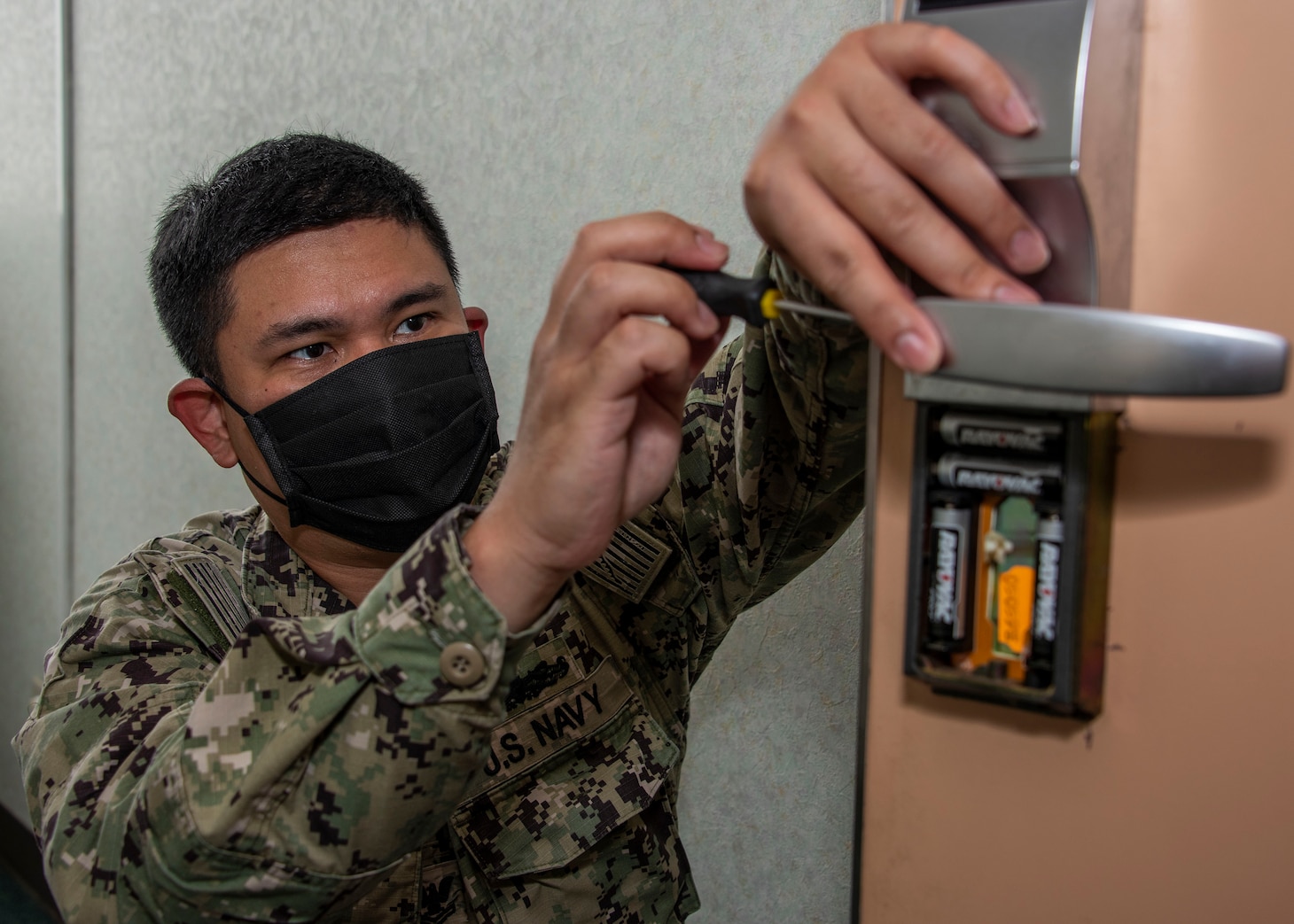 Culinary Specialist 2nd Class Jonathan Tongsen repairs a barracks bedroom door in building 1289 in preparation for new residents onboard Naval Air Facility (NAF) Atsugi.