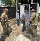 A contractor shows a group of personnel from the 475th Expeditionary Air Base Squadron base civil engineer team one of the transfer switches at Camp Simba, Kenya, that needs to be rewired. The 405th Army Field Support Brigade’s Logistics Civil Augmentation Program is working a letter of technical direction in order to conduct a project to access the feeder pillars and the distribution lines and cables that run throughout the east side of the camp. (U.S. Army courtesy photo)