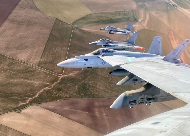 SPAIN (Feb. 22, 2023) An F/A-18E Super Hornet, attached to Strike Fighter Squadron (VFA) 86, and Danish F-16s fly over Spain during a tactical Leadership Program event, Feb. 22, 2023. Carrier Air Wing (CVW) 7 is the offensive air and strike component of Carrier Strike Group (CSG) 10 and the George H.W. Bush CSG. The squadrons of CVW-7 are VFA-86, VFA-103, VFA-136, VFA-143, Electronic Attack Squadron (VAQ) 140, Carrier Airborne Early Warning Squadron (VAW) 121, Helicopter Sea Combat Squadron (HSC) 5, and Helicopter Maritime Strike Squadron (HSM) 46. The George H.W. Bush CSG is on a scheduled deployment in the U.S. Naval Forces Europe area of operations, employed by U.S. Sixth Fleet to defend U.S., allied, and partner interests.