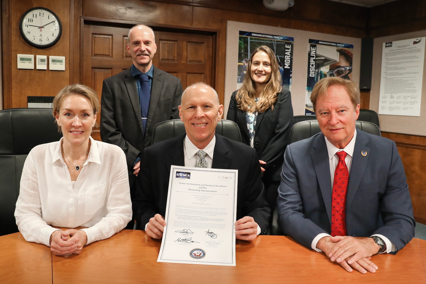 Naval Surface Warfare Center Indian Head (NSWC IHD) Technical Director Ashley Johnson (front center) displays a signed new public-private partnership agreement with X-Bow Launch Systems Inc., co-founder and Chief Revenue Officer Maureen Gannon (front left) and co-founder and Chairman of the Board Mark Kaufman (front right) during a March 24 signing ceremony. Also pictured are Deputy Technical Director Steve Anthony (back left) and Explosives and Energetics Division Director Bernadette Wackerle.