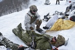 U.S. Army Sgt. Sam Rathbun, medic, Alpha Company, 3rd Battalion, 172nd Infantry Regiment (Mountain), 86th Infantry Brigade Combat Team (Mountain), Vermont Army National Guard, cares for a simulated casualty during Common Challenge 23 in the mountains around Kolašin, Montenegro, Feb. 6, 2023. Common Challenge 23 is a multinational exercise focused on integrating allied forces and conducting mountain warfare operations in severe terrain and weather with military members from the United States, Montenegro, Austria, North Macedonia and Italy forming a multinational mountain infantry company.