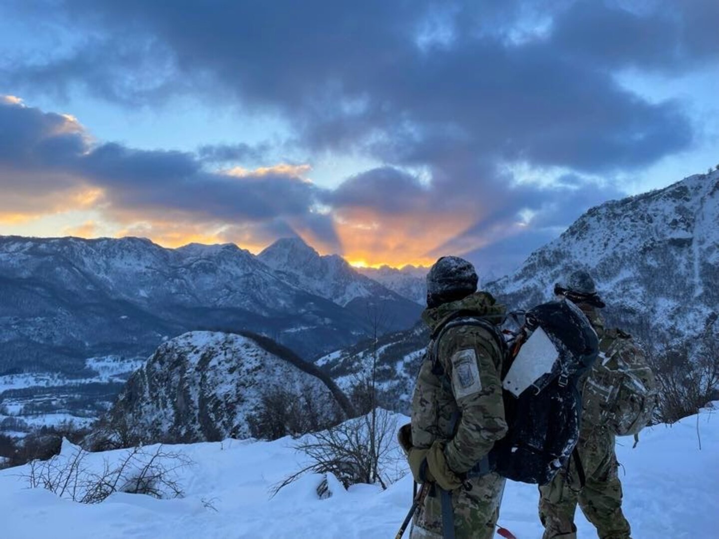 U.S. Army Soldiers from 3rd Battalion, 172nd Infantry Regiment (Mountain), 86th Infantry Brigade Combat Team (Mountain), watch the sun set over the mountains around Kolašin, Montenegro, on their descent from the summit during Common Challenge 23, Feb. 7, 2023.