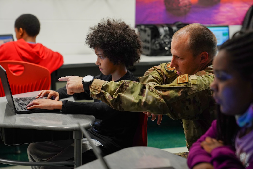 U.S. Air Force Tech Sgt. Shane Balkcom, 336th Training Squadron learning program manager, shows a student how to create basic algorithm blocks at Back Bay Elementary School on March 23, 2023. The 336th TRS collaborated with Back Bay Elementary to teach 4th grade students the basics of computer programing through a seven week course.