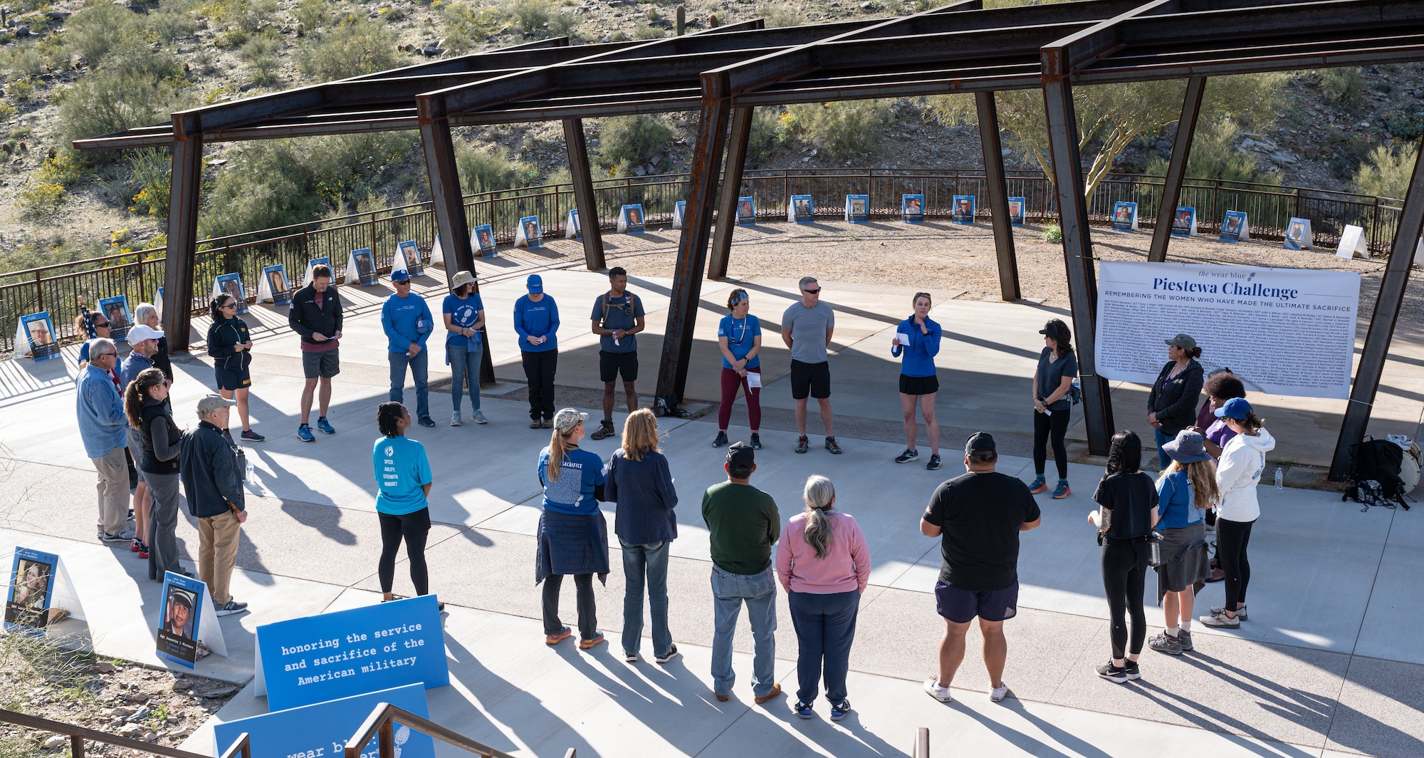 Service members from Luke Air Force Base and other participants at the Wear Blue: Run to Remember Piestewa Challenge stand in a circle March 26, 2023, at Piestewa Peak Trailhead in Phoenix, Arizona.
